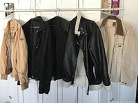 Image showing five men's jackets and coats hanging on a rack, varying in color and style