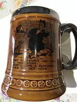 Photo of side view of ceramic beer mug showing main illustration and text with man and dog.