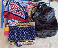 Five items shown: three Vera Bradley bags with floral and paisley patterns and two Vera Bradley beach towels with bold colors and branding. Items show signs of wear.