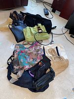 Overview of assorted bags on the floor showing variety of shapes, sizes, and materials