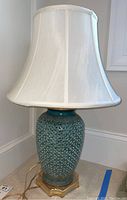 Full view of the blue ceramic table lamp with white fabric shade, showing overall shape and design.
