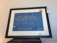 Framed Fenway Park blueprint wall art measuring 26x20 with architectural details and Boston Massachusetts labeling, taken angled to show frame and matting.