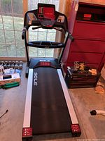 Front view showing running belt, handrails, and digital console