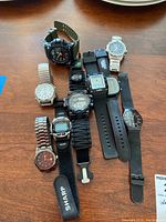 Group view on table: nine wristwatches and one pedometer strap