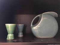 Side view of pitcher and two goblets, showing colors and shapes