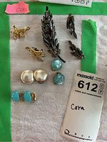 Full view of earrings and brooch from Coro, showing gold-tone birds, pearl and blue earrings, and silver leaf brooch with rhinestones.