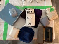 Multiple jewelry boxes arranged on table showing variety of colors, materials, and shapes.