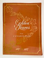 Front view of the softcover portfolio titled 'Golden Leaves from Canada's Past 1867-1967' with orange cover and gold maple leaf decorations.
