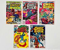 Photo showing all five Ghost Rider comic books spread out, each comic book freshly bagged and boarded, with bright colorful covers depicting Ghost Rider and related supernatural imagery.