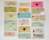 Top-down photo showing an assortment of old cancelled cheques and financial documents from Newfoundland banks, with various cancellation stamps and handwritten signatures.