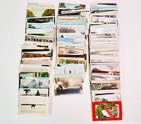 Overall view showing multiple stacks of vintage postcards with various themes and subjects.