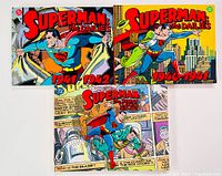 Three hardcover Superman graphic novels laid out, showing cover art with Superman in classic comic poses. Titles visible for 1940-1942 dailies and 1939-1943 Sunday Classics.
