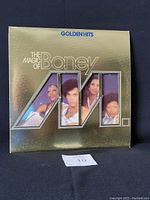 Front of the vinyl record jacket showing 'The Magic of Boney M. Golden Hits' with stylized AM logo and pictures of group members.