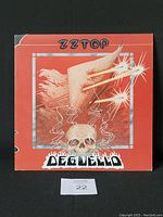 Front album cover displays the flaming skull and red artistic design with ZZ Top and Deguello title