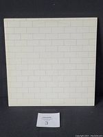 Front cover of the vinyl LP jacket showing white brick wall design with no text.