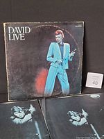 Front cover of 1974 David Bowie David Live vinyl record showing Bowie in blue suit with signs of wear