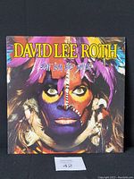 Front cover of the 1986 David Lee Roth "Eat 'Em and Smile" vinyl record album with colorful face paint art on the jacket.