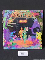 Front cover of Santana Amigos 1976 vinyl record jacket with colorful psychedelic art including human and animal figures.