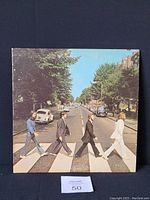 Front jacket cover showing The Beatles walking across zebra crossing on Abbey Road.