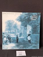 Front cover of The Moody Blues Long Distance Voyager vinyl album showing blue-toned vintage street scene art and album title.