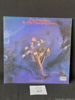 Front cover of The Moody Blues vinyl record 'On The Threshold of a Dream' showing psychedelic art with tree growing from mechanical arm.