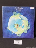 Front view of the Yes 1972 "Fragile" vinyl record jacket showing the artwork of a circular landmass surrounded by water with a small sailing ship, blue background.