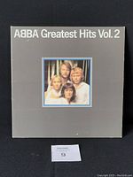 Front cover of ABBA Greatest Hits Vol. 2 vinyl record showing grey jacket with image of ABBA band on center front.
