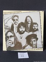 Front photo of The Doobie Brothers Minute by Minute vinyl record jacket showing band members in sepia tone, with punched hole visible in top left corner.