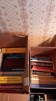 Photo showing two boxes containing a variety of books including Canadian Amateur Radio Licensing Manual and art titles.