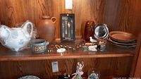 Shelf with all lot items including cow-shaped tea pot, jug, pate dish, coffee spoons, plates, and animal figurines