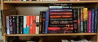 Bookshelves with hardcover and paperback novels by authors including Mary Stewart, Julie Garwood, and Iris Johanson, among others.
