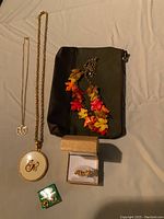 Lot contents showing all jewelry and storage pouch on fabric background