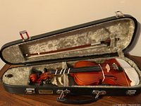 Violin inside the case with bow and white cloth on chin rest