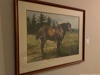Framed watercolour print of a working farm horse with harness depicted in a grassy field with tree line in background, hung on a wall.
