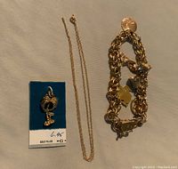 View of all items: cocktail glass charm on card, rope chain, charm bracelet