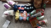 Photo of assorted skeins of yarn including Mary Maxim Bolero and Royale yarn brands, and packaged craft kits