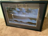 Photo showing the black framed and double matted lighthouse print resting against a wall.