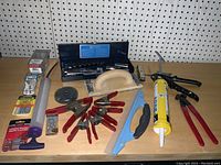 Overview of all included tools spread out on a wooden surface to show the variety of tools and hardware included in the lot.