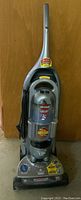 Front view of the Bissell upright vacuum cleaner showing clear dust bin and control panel.