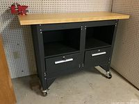 Front view of metal workbench with wooden top and attached red Home Hardware vise