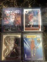 Four Scottie Barnes rookie cards in protective sleeves, featuring different card designs including prizm parallel and NBA Hoops series.