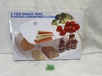 Front of original box showing 2-tier snack tray with assorted snacks.