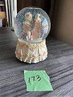 Front view of the Bainbridge Bears musical snow globe showing teddy bear at piano inside the globe and the decorative base.