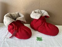 Front and side view of the red Cozy Soles heated slippers with plush sherpa lining and velcro adjustable strap.