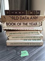 Stacked Encyclopedia Britannica annual year books including 1987, 1988, and 1990 editions in original packaging.