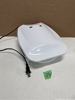 Full top and side view of white electric contact grill with power cord and indicator lights.