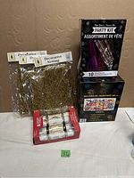 Overview of party kits, decorative netting, and party crackers in original packaging on table.