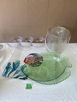 Display of fish-themed serveware platters, clear 3-section dish, and ice bucket with lid and handle on a white surface.