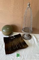 Full view of all items including the square birch tree platter, green ceramic ball, and metal wire bird cage on wooden bases.