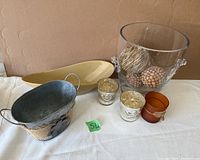 View of all items together showing diverse table decor pieces including glass bowl with balls, metal bucket, ceramic dish, and votive holders.